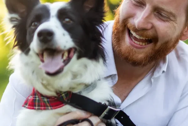 A smiling man with his border collie